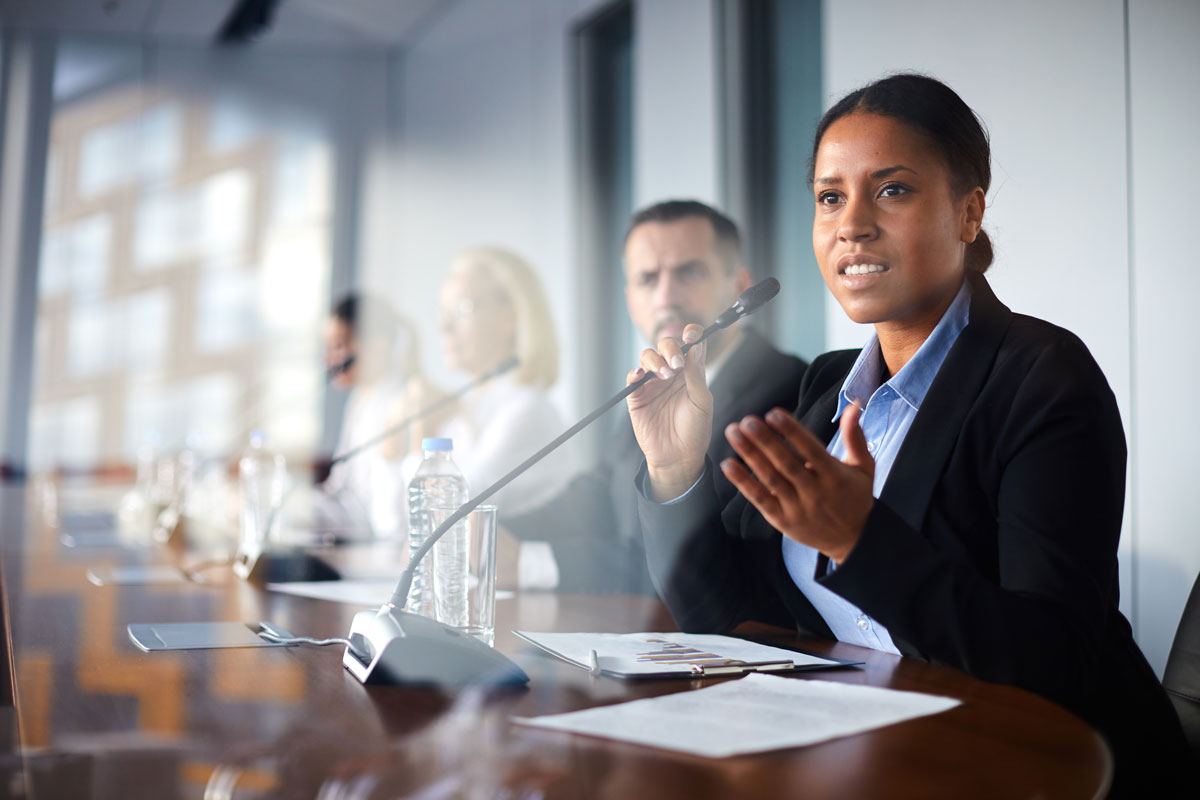 Professional woman speaking with a microphone at a global policy meeting